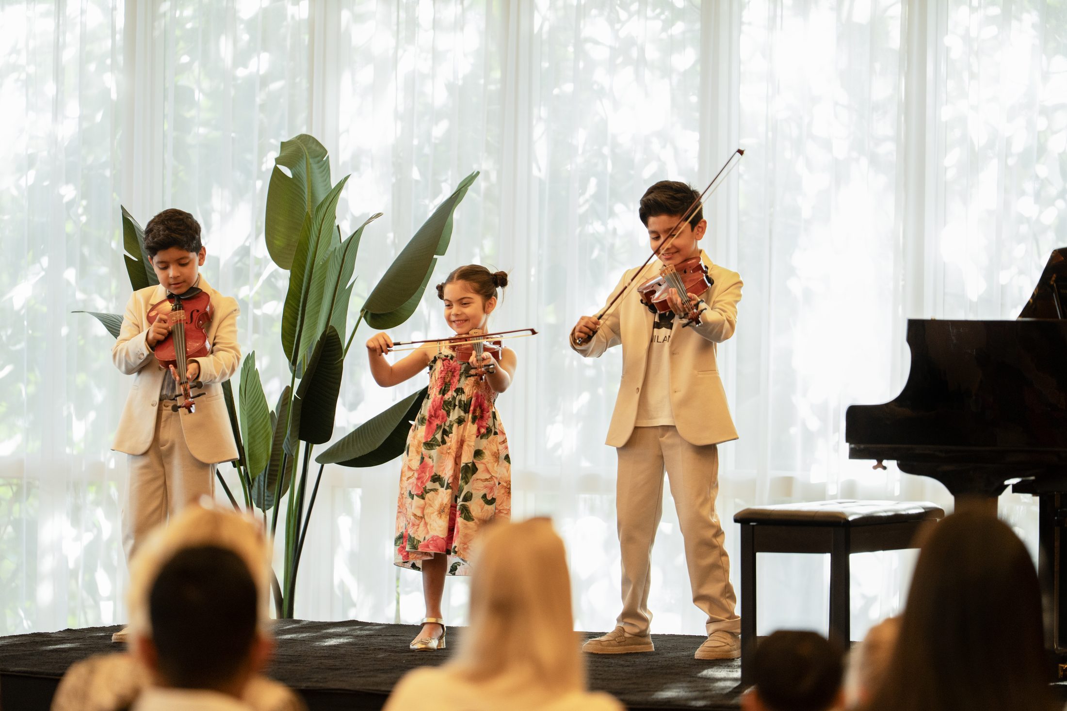 Young violinists performing together at an MJ Strings recital in Dubai