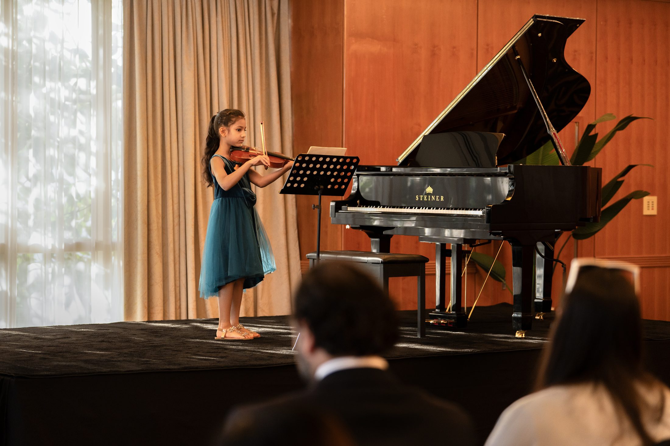 A student violinist performing at an MJ Strings concert in Dubai