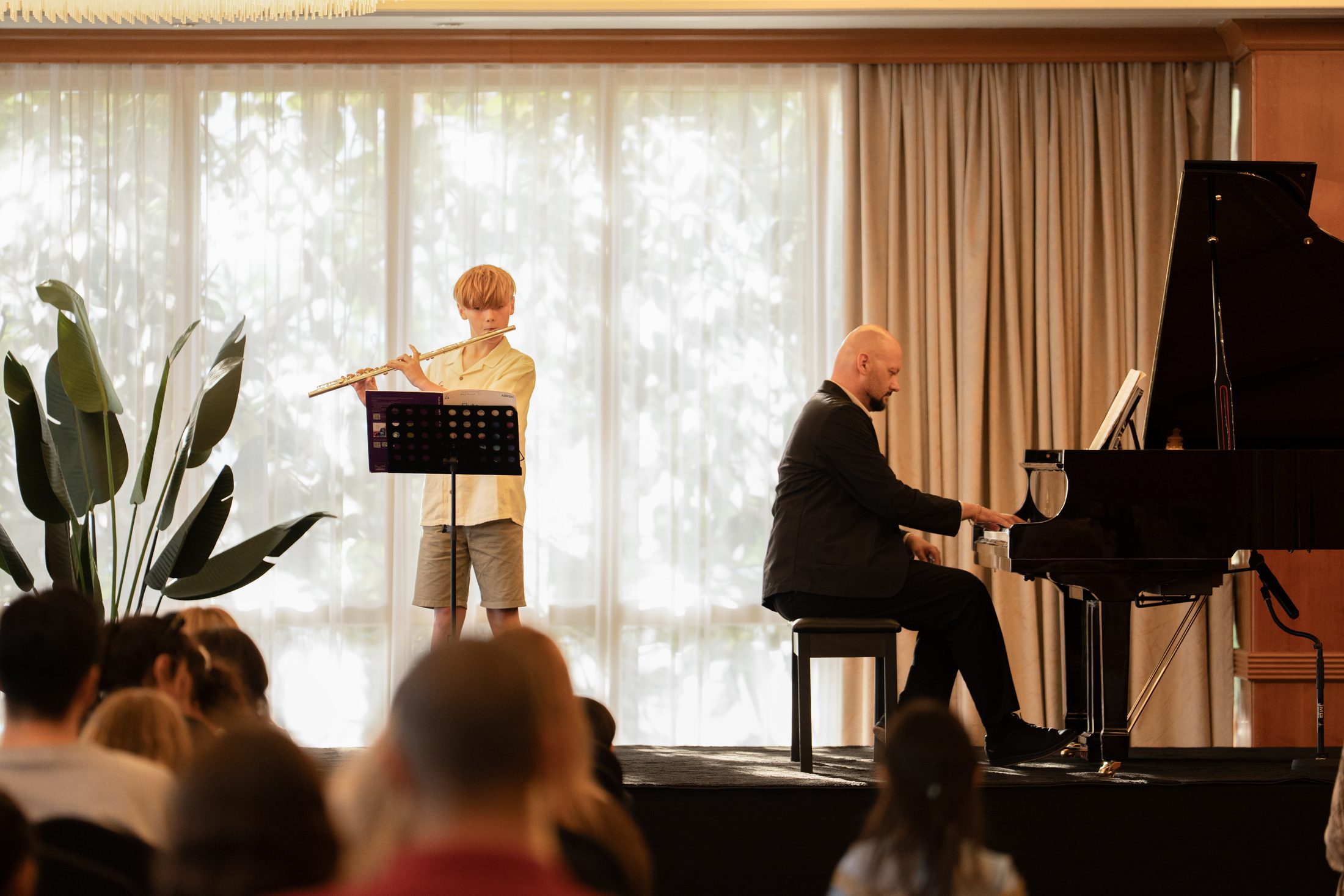 A student playing the flute at an MJ Strings concert in Dubai