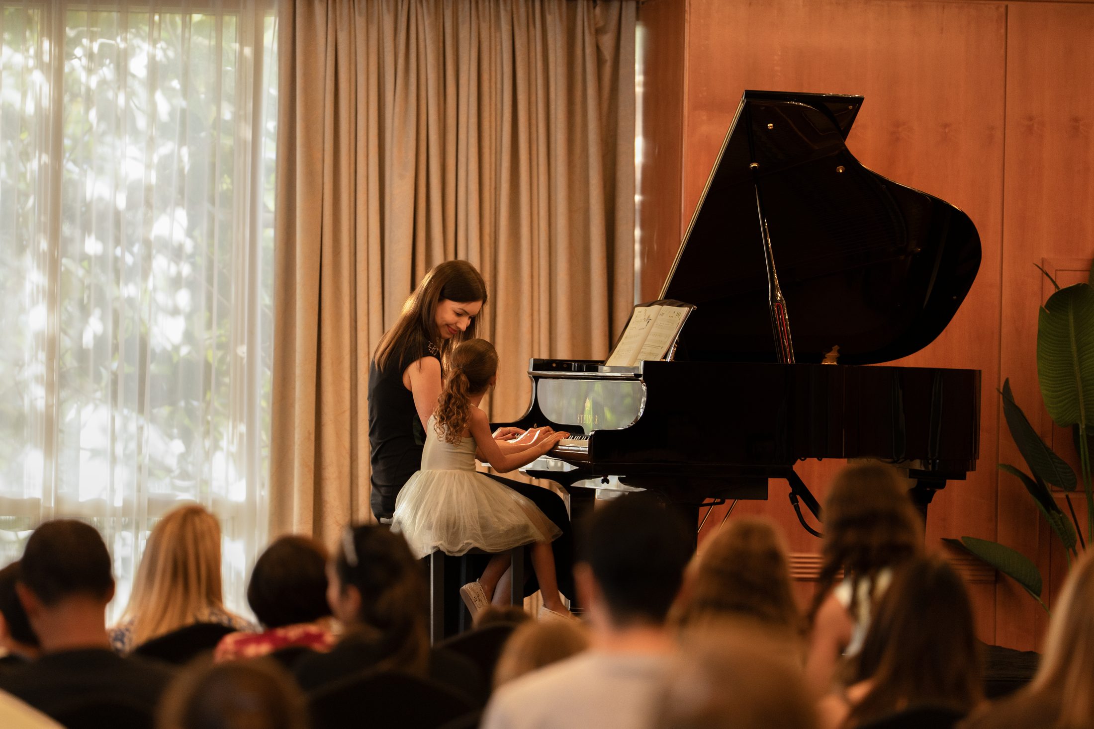 A student and teacher performing together at an MJ Strings recital in Dubai